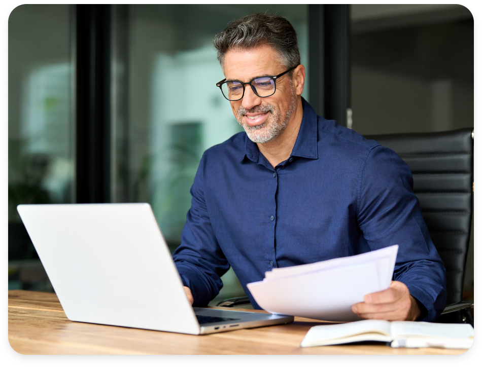 CPA reviewing documents at a laptop